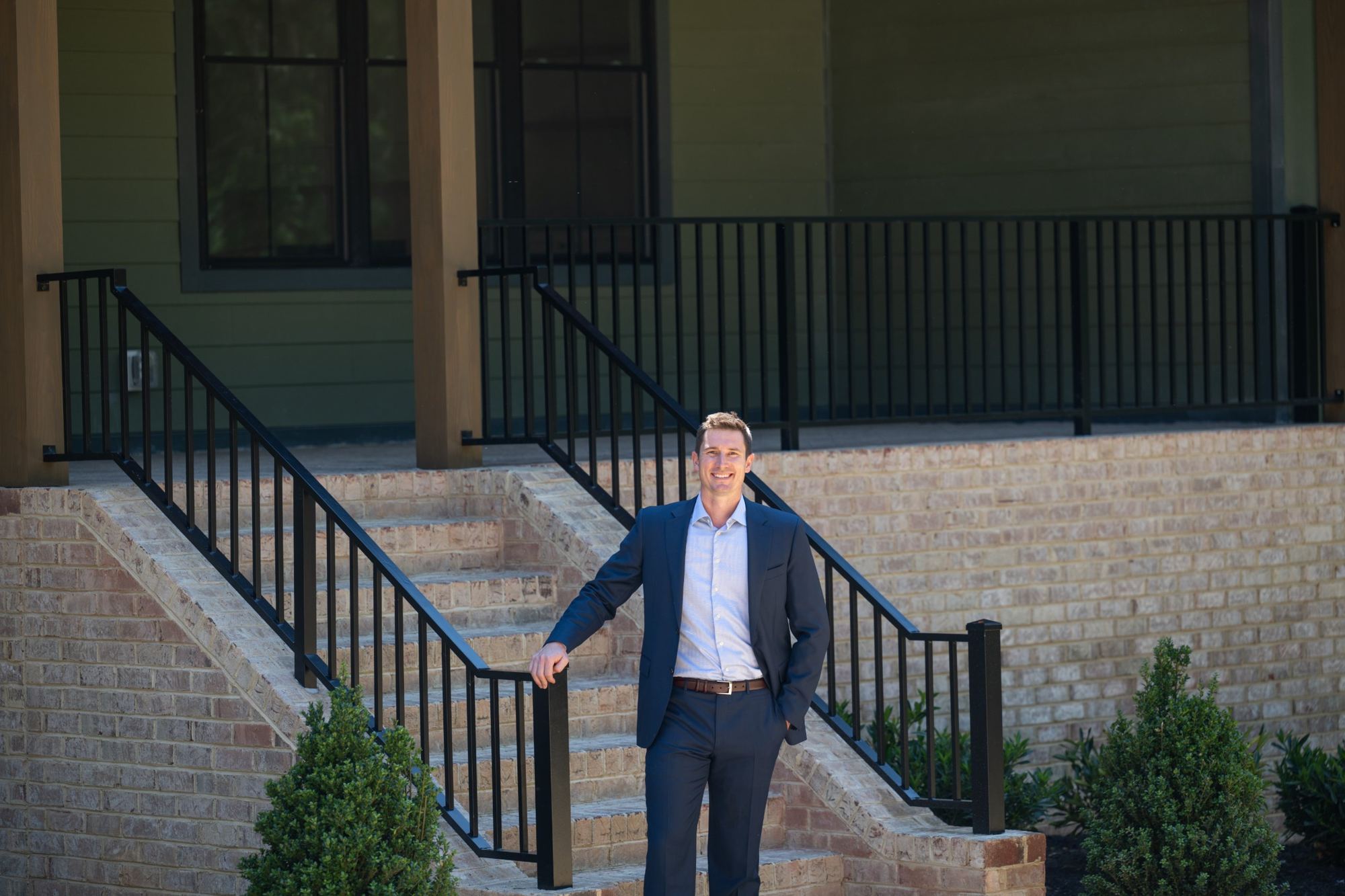 Adam Tuck on the front steps of the Foxtail with Basement at Sheppard Grove, a home he developed and built